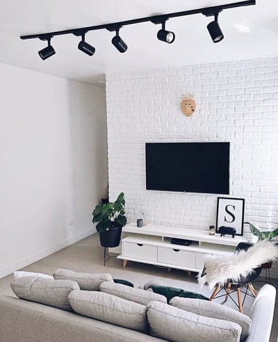 Sala com decoração minimalista com rack e sofá cinza