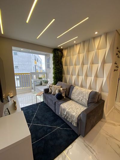 Sala com sofá cinza e parede com revestimento 3d de gesso