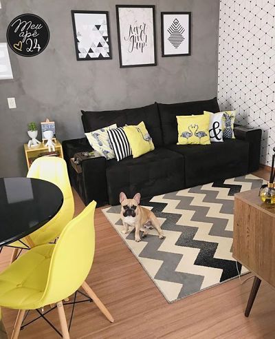 Sala com sofá preto e almofadas amarelas