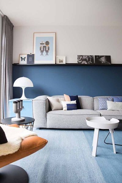 Sala com parede azul e sofá cinza