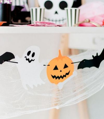 Decoração halloween com papel cortado em formato de abóbora e morcego 