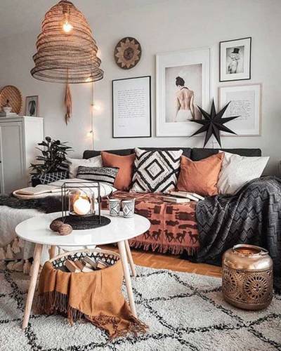 Sala com sofá preto e almofadas estilo boho chic