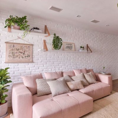 Sofá retrátil rosa claro e parede de tijolinho branco