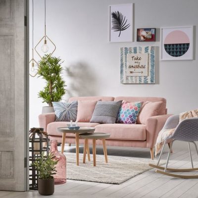 Sala com sofá rosa e quadros na parede 