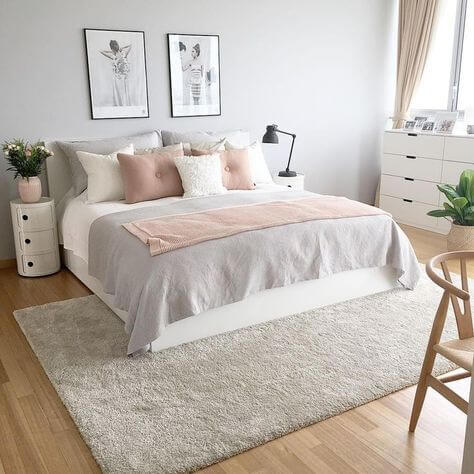 Tons Pastéis Na Decoração: dicas e inspirações Tom pastel no quarto com cama e almofadas, tapete grande e quadros na parede.