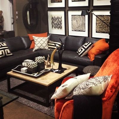 Sala com sofá preto e amofadas coloridas