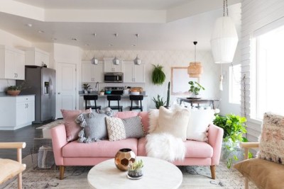 Sala grande com sofá rosa com almofadas 