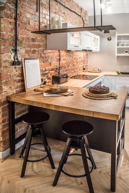 Cozinha americana com decoração industrial e parede de tijolinho aparente