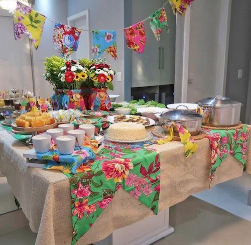 Decoração festa junina na mesa com comidas e bandeirinhas 