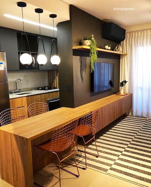 Cozinha preta e madeira integrada com a sala pequena 