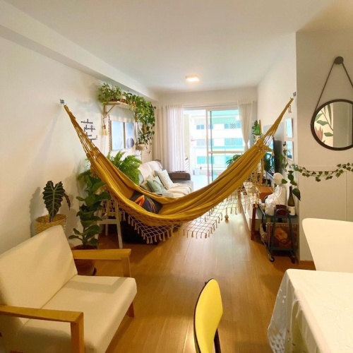 Sala pequena de apartamento com rede de descanso amarela