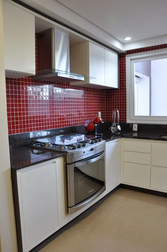 cozinha simples com armario branco e azulejo vermelho