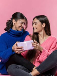 Mãe e filha sorrindo trocando presente de Dia das Mães